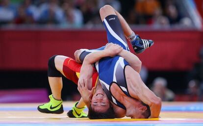 El búlgaro Ivo Serafimov Angelov (de azul) se enfrenta al chino Jiang Sheng en la competición de lucha, 60 kg.