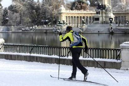 Un hombre utiliza los esquís para transitar en la mañana de ayer por el parque madrileño del Retiro, cubierto por un manto de nieve.