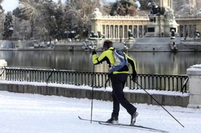 Un hombre utiliza los esquís para transitar en la mañana de ayer por el parque madrileño del Retiro, cubierto por un manto de nieve.