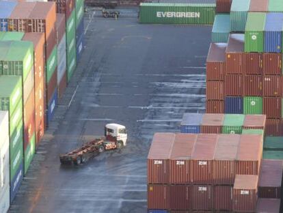 Varios contenedores de carga apilados en un puerto.