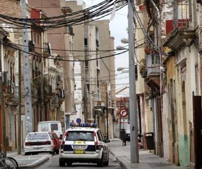 Un vehículo de la Policía Local de Valencia patrulla por una de las calles más degradadas del barrio marinero de El Cabanyal, en Valencia.