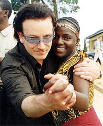 El cantante Bono baila en Kampala con una niña, huérfana a causa del sida.