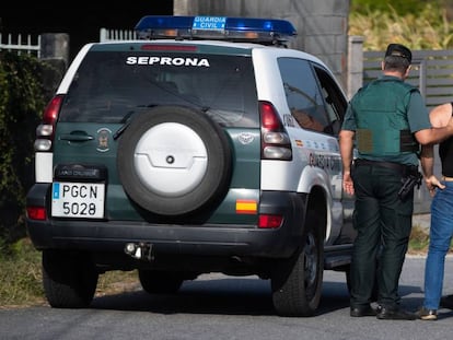 Civil Guard officers with a neighbor of the victims.