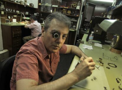 Pedro Ortiz Rey, en el taller de su tienda, Losada. Y su socio, Jesús López-Terradas, al fondo.