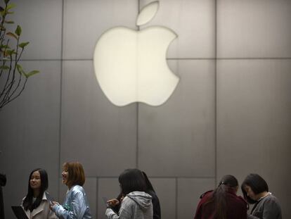 FILE - In this Friday, Oct. 20, 2017, file photo, people stand in line near an Apple Store at an outdoor shopping mall in Beijing, China. On Wednesday, Jan. 17, 2018, Apple announced it is planning to build another corporate campus and hire 20,000 workers during the next five years as part of a $350 billion commitment to the U.S. economy. (AP Photo/Mark Schiefelbein, File)