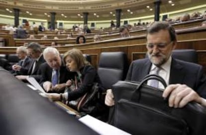 El presidente del Gobierno, Mariano Rajoy (d), junto a la vicepresidenta, Soraya Sáenz de Santamaría (2d), y el ministro de Asuntos Exteriores, José Manuel García-Margallo (3d), al inicio hoy del pleno del Congreso de los Diputados.