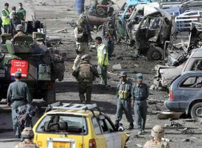 Fuerzas de seguridad afganas y soldados de la ISAF custodian el lugar del atentado contra un convoy de la OTAN en Kabul.