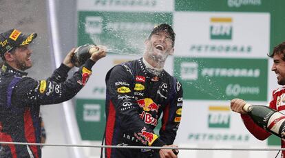 Vettel y Alonso riegan de champán a Webber.