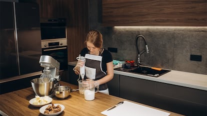 Una mujer usando la batidora en la cocina