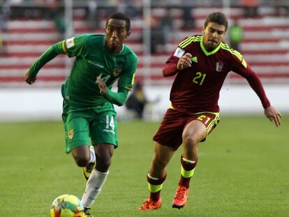 El jugador Jaime Arrascaita de la selección boliviana de fútbol disputa el balón con Alexander González de Venezuela.