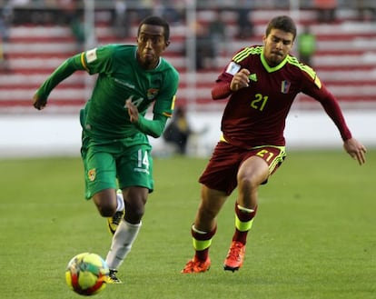 El jugador Jaime Arrascaita de la selección boliviana de fútbol disputa el balón con Alexander González de Venezuela.