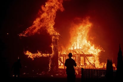 El incendio ha comenzado este jueves y rápidamente ha calcinado 3.237 hectáreas, forzando la evacuación de los residentes de Paradise. En la imagen, las llamas consumen una casa en esta ciudad californiana.