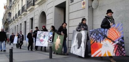 Algunos de los participantes de la iniciativa transportan sus obras por la calle Alcalá.