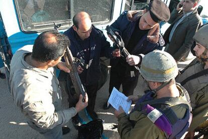 Militares israelíes comprueban el estado de las armas de agentes de seguridad palestinos.