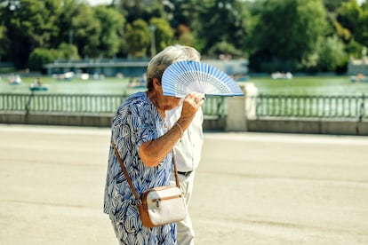 Una mujer se protege del sol con un abanico, este lunes en el Parque de El Retiro de Madrid.