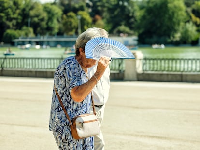 Una mujer se protege del sol con un abanico, este lunes en el Parque de El Retiro de Madrid.