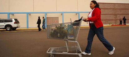 Una mujer lleva un carrito de supermercado en La Quinta (California).