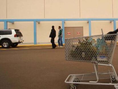 Una mujer lleva un carrito de supermercado en La Quinta (California).
