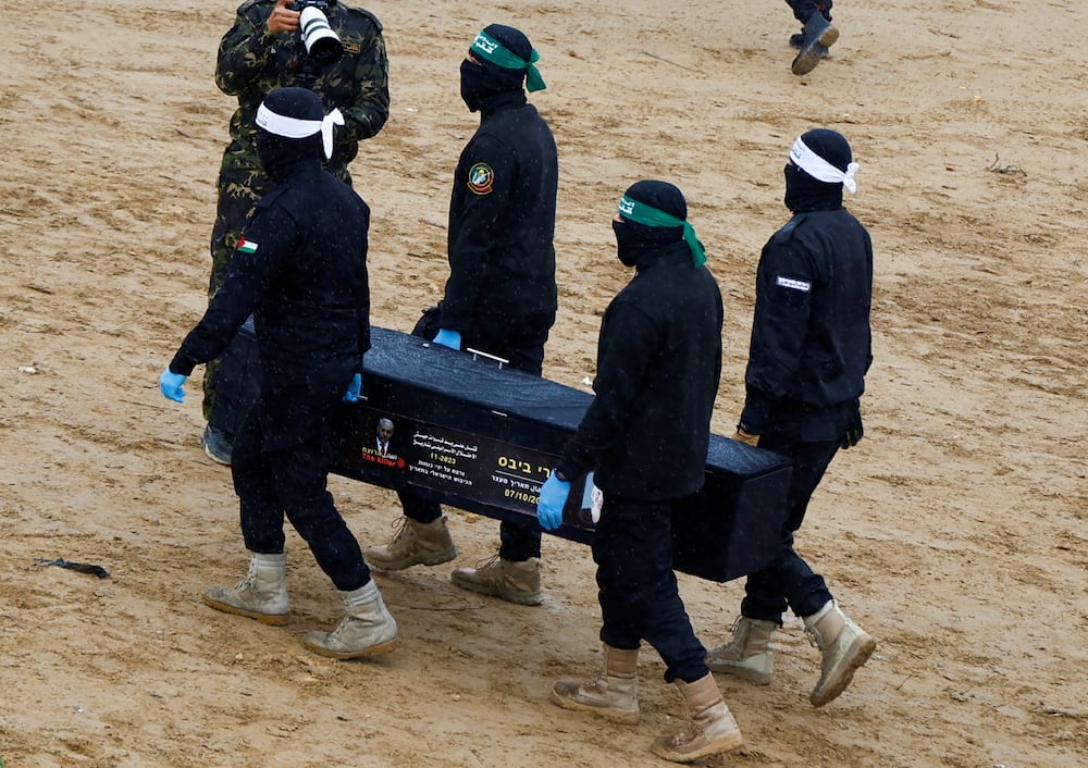 Palestinian militants carry a coffin on the day Hamas hands over deceased hostages Oded Lifschitz, Shiri Bibas and her two children Kfir and Ariel Bibas, seized during the deadly October 7, 2023 attack, to the Red Cross, as part of a ceasefire and hostages-prisoners swap deal between Hamas and Israel, in Khan Younis in the southern Gaza Strip February 20, 2025. REUTERS/Hatem Khaled