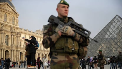 Un soldado armado custodia la entrada del Louvre.