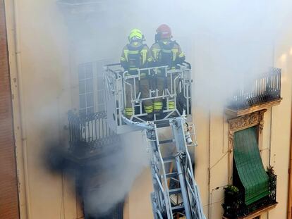 Los bomberos trabajan en la extinción del incendio de una vivienda en el barrio valenciano de Russafa.