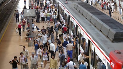 Decenas de viajeros en torno a un tren de Cercan&iacute;as de Renfe en Madrid.