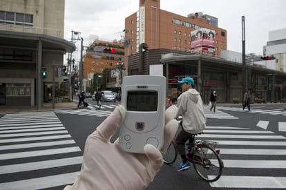 Un experto mide la contaminación en una calle de Koriyama, a 60 kilómetros de la planta nuclear de Fukushima, en el noroste de Japón. El Gobierno ha ampliado a 40 kilómetros el radio de evacuación de la central.