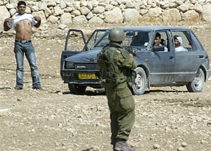 Un soldado israelí identifica a uno de  los ocupantes de un vehículo palestino cerca de Hebrón.