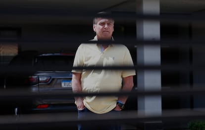 El expresidente de Brasil Jair Bolsonaro se asoma a la puerta de su chalet, donde está en arresto domiciliario, este jueves, en Brasilia.