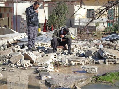 Dos hombres sirios junto a un edificio destruido en una zona inundada, tras el colapso de una presa en el río Orontes, cerca del pueblo de al-Tulul, en la provincia de Idlib.