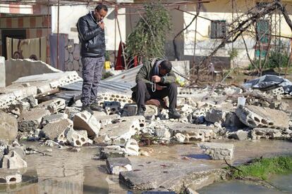 Dos hombres permanecían el jueves junto a los restos de una casa caída en una zona inundada por la rotura de una presa tras el terremoto, en la provincia siria de Idlib.