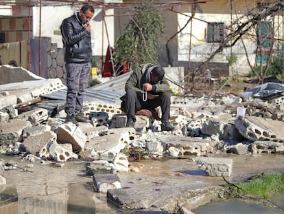 Dos hombres sirios junto a un edificio destruido en una zona inundada, tras el colapso de una presa en el río Orontes, cerca del pueblo de al-Tulul, en la provincia de Idlib.