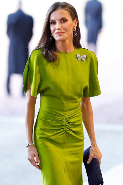 La elección de Letizia Ortiz ha sido uno de sus grandes aciertos estilísticos de este año. Primero,  por el detalle de elegir una diseñadora británica en un día tan señalado para Inglaterra. Segundo, por elevarlo y hacerlo suyo al adornarlo con un espectacular broche en forma de lazo. El broche perteneció a María Cristina de Austria esposa de Alfonso XII de España, tatarabuelo de don Felipe, y transformaba por completo el vestido, que le quedaba como un guante.