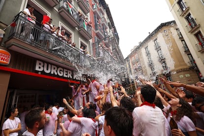 Un gruppo di persone lancia secchiate d'acqua da un balcone contro gli spettatori del chupinazo (fuochi d'artificio) di Pamplona questa domenica.