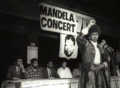 Winnie Mandela saluda con su puño en alto tras anunciar un concierto por el 70 cumpleaños de su marido, Nelson Mandela, en 1988.