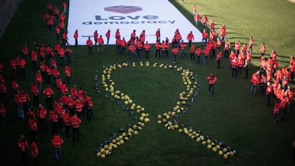 Bomberos forman un gran lazo amarillo con sus cascos en Barcelona.