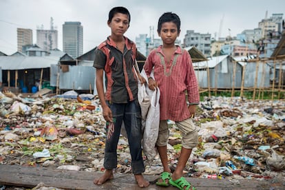 Shopon (11 años) y Akash (10 años) en el vertedero en el que trabajaban. El pequeño, sin zapatos, se hacía cortes en los pies con los desechos punzantes, además de estar expuesto a las infecciones por los gusanos y animales muertos en el lugar.