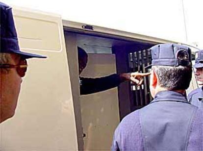 Uno de los 24 nigerianos que van a ser repatriados es introducido en un furgón policial.