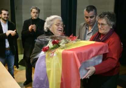 El vicepresidente de la asociación, el escritor berciano Santiago Macías, efectúa la entrega de los cuerpos envueltos en una bandera republicana, ayer en el Auditorio de Cambados.