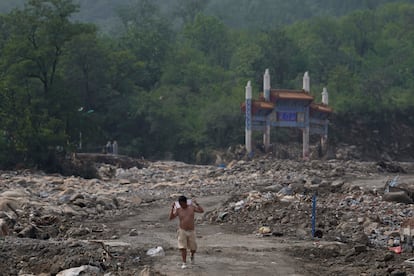 En 2021 y 2022, los veranos estuvieron marcados por unas precipitaciones de una intensidad inédita en décadas en el centro del país que causaron más de 300 muertos y por una persistente sequía en el centro y el sur, respectivamente.  En la imagen, un hombre camina por una zona afectada por las inundaciones en Nanxinfang, este viernes.