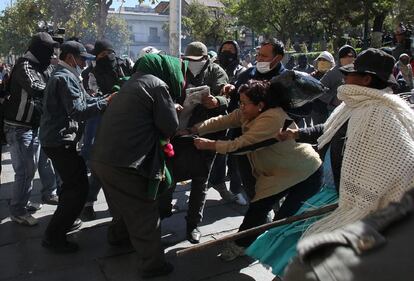 Esposas y policías amotinados se enfrentan a indígenas aimaras fieles al presidente de Bolivia, en las puertas del palacio de Gobierno en La Paz.
