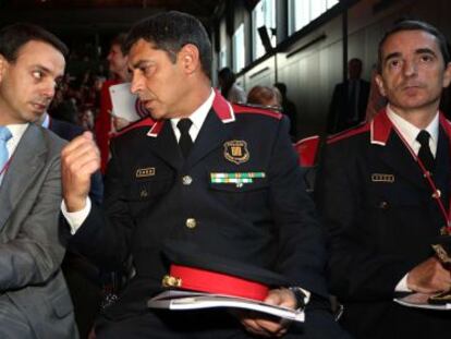 Manel Prat, a la izquierda, junto a dos mandos de los Mossos, en en un acto de esta mañana en el Born.