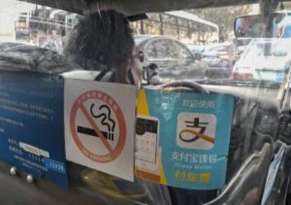 Un taxi de Shanghái muestra en la mampara de seguridad el logotipo de Alipay, cada vez más extendido también por el transporte.