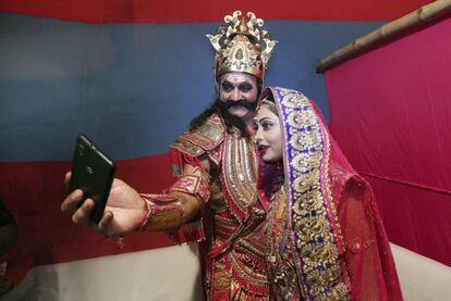 Los actores de Bollywood Surendra Pal (i), en el papel de rey Ravana, y Rupa Dutta, en el papel de Sita, posan para un selfie antes de su actuación en la representación teatral del "Lord Rama" (Ramayana) titulada Ramleela, en Nueva Delhi (India).