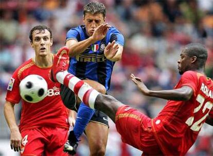 Crespo disputa un balón con dos defensores del Sevilla durante un partido de pretemporada.