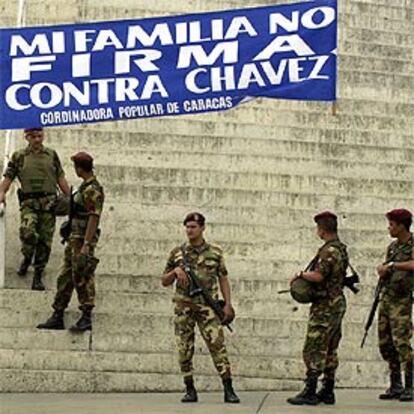 Miembros de la Guardia Nacional venezolana bajo un cartel de apoyo a Chávez, ayer en Caracas.