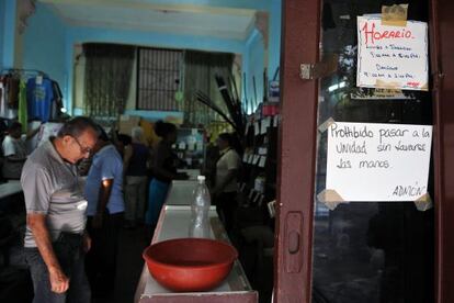 Un cartel advierte a los visitantes de una tienda en La Habana de lavarse las manos antes de ingresar.