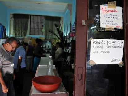 Un cartel advierte a los visitantes de una tienda en La Habana de lavarse las manos antes de ingresar.