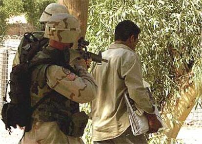 Un soldado estadounidense detiene a un vendedor de periódicos ayer en Bagdad.