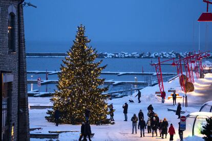 People walk around a Christmas tree decorated for the Christmas and New Year festivities at the Noblessner port in the Tallinn Bay, Estonia, Saturday, Dec. 16, 2023.